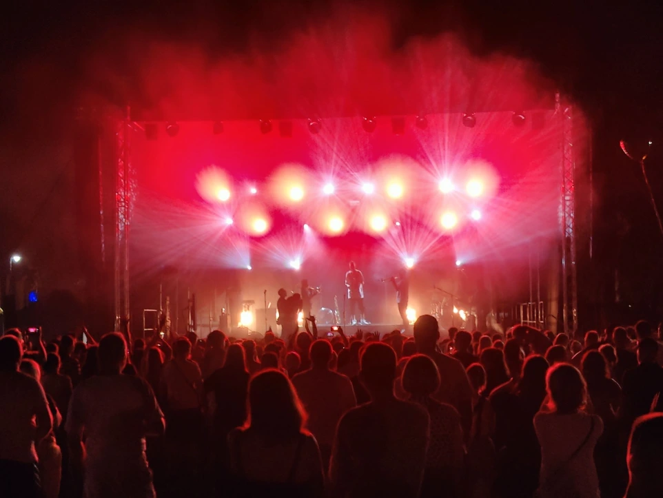 Koncert z profesjonalnym nagłośnieniem i czerwonym oświetleniem scenicznym